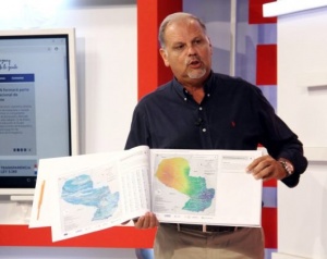 El ministro Joaquín Rosa exhibe el Atlas Nacional de Riesgos, que contiene datos para la mitigación de desastres naturales.